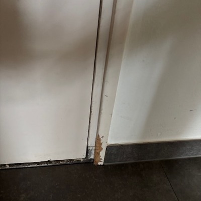 Plank is onder de vensterbank vandaan gevallen. Graag muur vullen, en plint tegenaan plakken.  In de gang graag de hoeken netjes maken, heeft hond als pup aan geknaagd.