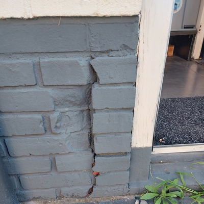 Herstel beschadiging stukje stenen muur bij de achterdeur (opnieuw inmetselen stenen)